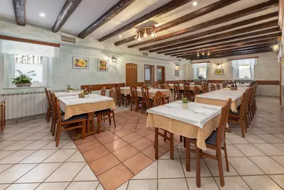 a restaurant with tables and chairs in a room at Ražman Wine Rooms in Gračišče