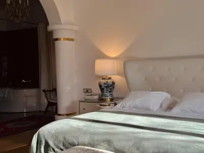 a bedroom with a large bed and a lamp on a table at Adora Luxury Hotel in Bled