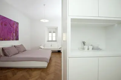 a white room with a couch and a table at Galeria River in Ljubljana