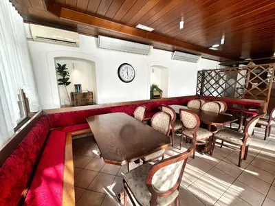 a restaurant with a red couch and tables and chairs at Youth Hostel Bledec in Bled