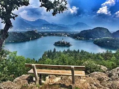 a bench sitting on top of a hill overlooking a lake at Youth Hostel Bledec in Bled