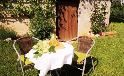 a white table with two chairs and flowers on it at Rooms Zupančič in Bohinjska Bela