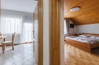a bedroom with a bed and a table and a chair at Rooms Zupančič in Bohinjska Bela