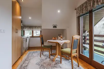 a kitchen and dining room with a table and chairs at Rooms Zupančič in Bohinjska Bela