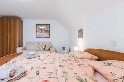 a bedroom with a bed with a floral bedspread at Rooms Zupančič in Bohinjska Bela