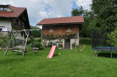 a playground in front of a house with a slide at Rooms Zupančič in Bohinjska Bela