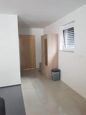 an empty room with a door and a trash can at Apartmaji Janković in Logatec