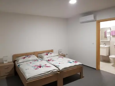 a bedroom with a bed and a bathroom at Apartmaji Janković in Logatec