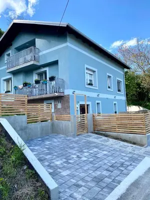 a blue house with a wooden fence in front of it at LizMari in Podčetrtek