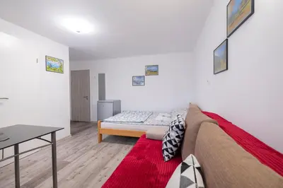 a living room with a couch and a table at Studio Southwest 2 semi-basement in Ljubljana