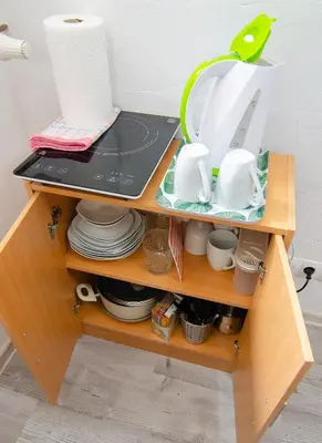 a wooden shelf with dishes and utensils on it at Studio Southwest 2 semi-basement in Ljubljana