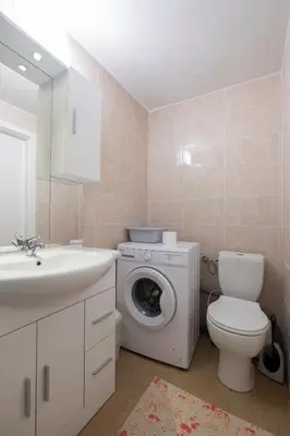 a bathroom with a washing machine and a sink at Studio Southwest 2 semi-basement in Ljubljana