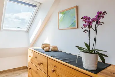 a room with a dresser with a vase of flowers on it at Pr'Jernejc Agroturism in Lesce