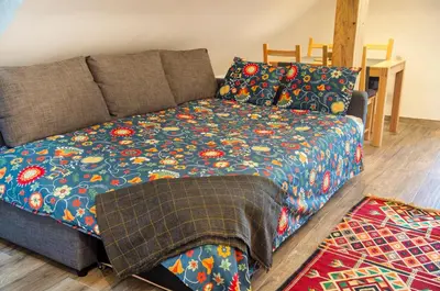 a bed in a living room with a blanket on it at Pr'Jernejc Agroturism in Lesce