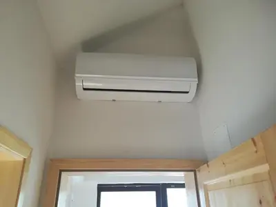 a white air conditioner in a room with a window at Pr'Jernejc Agroturism in Lesce