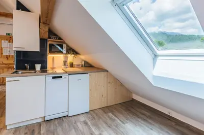 a kitchen with white cabinets and a large skylight at Pr'Jernejc Agroturism in Lesce