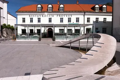 a building with a bridge in front of a building at Postojna Cave Rooms & Apartments Proteus in Postojna