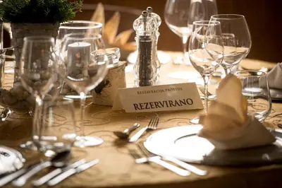 a table with wine glasses and silverware on it at Postojna Cave Rooms & Apartments Proteus in Postojna