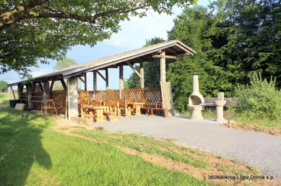 a wooden pavilion with benches in a park at Small wooden houses and Apartments Zgornja Dobrava in Radovljica