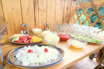 a wooden table with plates of food on it at Small wooden houses and Apartments Zgornja Dobrava in Radovljica