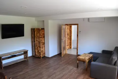 a living room with a couch and a tv at Small wooden houses and Apartments Zgornja Dobrava in Radovljica