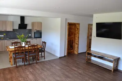 a kitchen and dining room with a table and chairs at Small wooden houses and Apartments Zgornja Dobrava in Radovljica