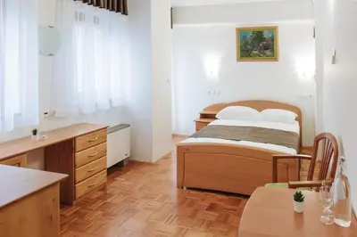 a bedroom with a bed and a desk and a kitchen at Rooms Reaktiv in Zreče