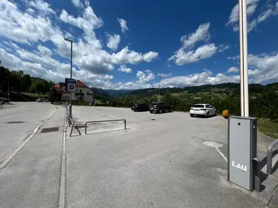 a parking lot with cars parked in front of a building at Rooms Reaktiv in Zreče