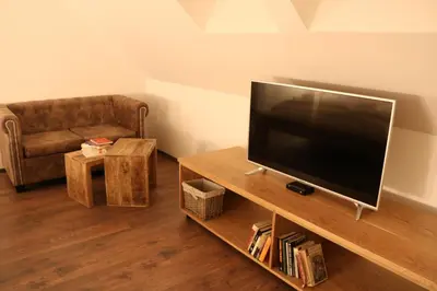 a living room with a flat screen tv and a couch at Gorska Reka Guesthouse in Zreče