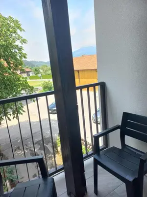 a chair on a balcony with a view of a street at Sobe Levc in Mozirje