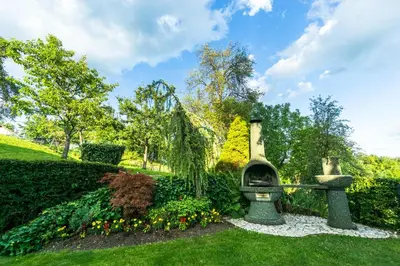 a garden with a stone bench in the grass at Holiday House in Nature with Pool, Pr Matažič in Kamnik
