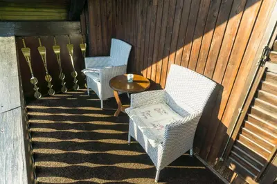 a porch with two chairs and a table and a fence at Holiday House in Nature with Pool, Pr Matažič in Kamnik