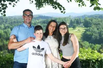 a family posing for a picture in the mountains at Holiday House in Nature with Pool, Pr Matažič in Kamnik
