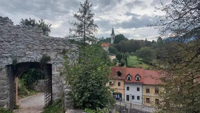 an archway in a stone wall next to a village at Holiday House in Nature with Pool, Pr Matažič in Kamnik