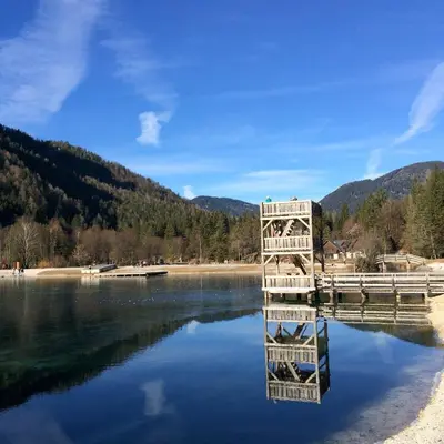a reflection of a building in the water at Auredius Deluxe Apartment in Kranjska Gora