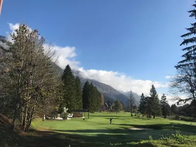 a view of a golf course in the mountains at Auredius Deluxe Apartment in Kranjska Gora