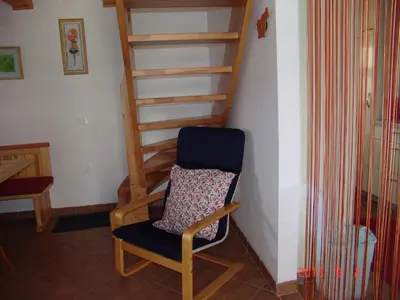 a chair in a room with a stair case at Apartments Lana in Bled