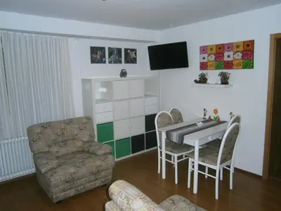 a living room with a table and a chair at Apartments Lana in Bled