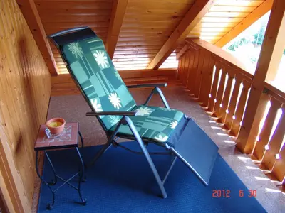 a green rocking chair in a cabin with a table at Apartments Lana in Bled
