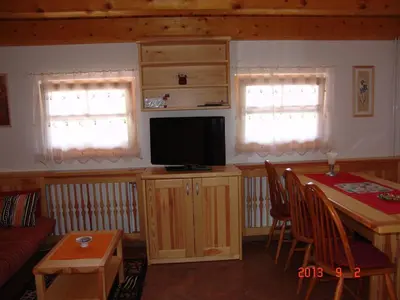 a living room with a television and a table with chairs at Apartments Lana in Bled