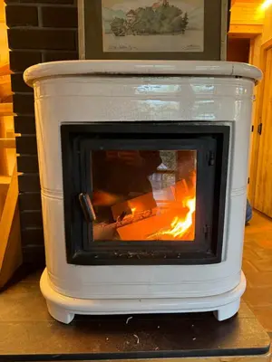 a white stove with a fire inside of it at Alice Chalet Bled - Adults only in Bled