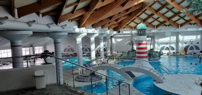 a large swimming pool with a lighthouse in a building at Boho House 5 camp Terme Catez with promotional tickets prices in Čatež ob Savi