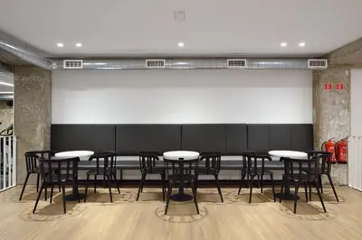 a group of tables and chairs in front of a wall at Accommodation Vitalis in Ljubljana