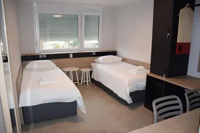 a room with two beds and a table and a window at Accommodation Vitalis in Ljubljana