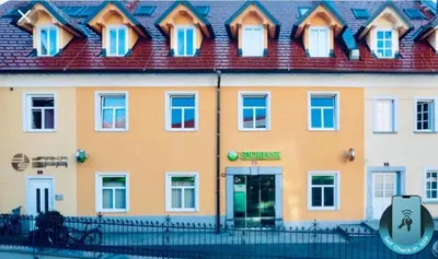 a large yellow building with a red roof at Apartment Na skali in Kranj