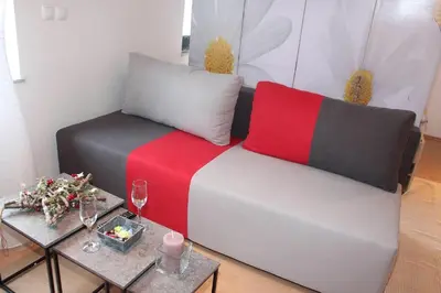 a living room with a couch and two tables with wine glasses at Apartment Na skali in Kranj