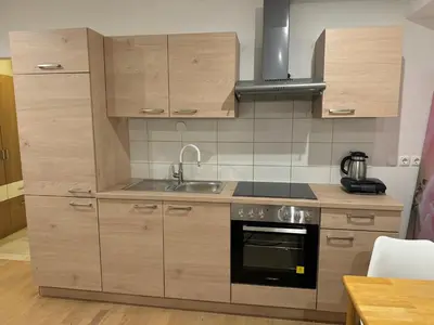 a kitchen with wooden cabinets and a sink at Apartment Na skali in Kranj