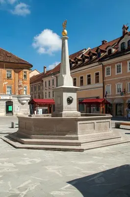 a monument in the middle of a square with buildings at Apartment Na skali in Kranj