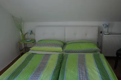 a bedroom with a bed with two green and purple pillows at Apartments Mencinger in Bohinj