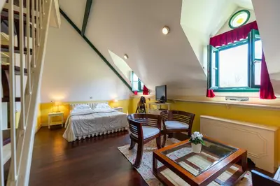 a attic bedroom with a bed and a table at Boutique Hotel Dobra Vila Bovec in Bovec